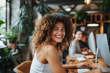 Wall Mural - Business woman typing on a laptop at a wooden table in a modern office.