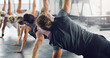 © ArcursPI/peopleimages.com - Side, plank and people in gym for workout, group exercise class and muscle development. Back, team warm up and stretching together for health with strong body, sports training and balance challenge