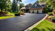 © Wanlop - Freshly applied black sealcoat glistens on a newly restored asphalt driveway, with clean edges and subtle texture visible.