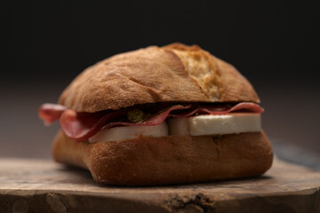 Wall Mural - Sandwich with bresaola, mozzarella and pest on olive board