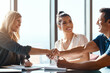 © ReeseArcurs/peopleimages.com - Meeting, couple and financial advisor with handshake for deal, agreement or greeting in office. Welcome, help and woman broker with people shaking hands for contract, loan application or investment