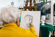 © ADDICTIVE STOCK - Elderly woman creating art in a studio environment