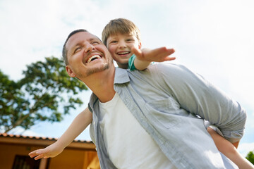 Wall Mural - Father, kid and piggyback in backyard for fun, love and bonding to connect in childhood at home. Daddy, carrying son and adventure game for airplane flying in outdoor, happiness and care or support