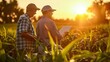 © Attasit - Happy two smart farmer holding a tablet inspecting walking through the corn field, sunset scene