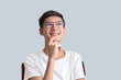 © Praewphan - Closeup photo of head shot of intelligence teenager boy in eyeglasses look up deep thinking, happy feeling to get and answer of his doubt isolated on white empty space deep thinking creative concept.