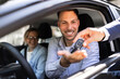© Andrey Popov - Smiling Hispanic Salesman Successfully Handing Over Keys to New Car Owners