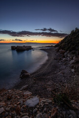 Hidden bay in sunrise. Looked at the small sand, pebble, beach in warm colors and the morning light. View of the sea at Xigia Sulfur Beaches, Ionian Islands, Greece