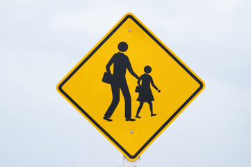 school zone sign is on light blue sky.