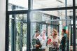 © peopleimages.com - Woman, team and collaboration with notes on board with review, listening and planning with brainstorming. Coach, training and group by glass wall, questions and discussion with strategy in office