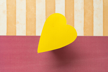 Wall Mural - top-down shallow depth of field focus on a yellow heart with decorative scrapbooking paper background