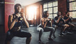 © peopleimages.com - Group, exercise and training with kettlebell to squat in class for muscle, wellness or healthy body. Team, fitness and strong people weightlifting for power, bodybuilding and workout together at gym