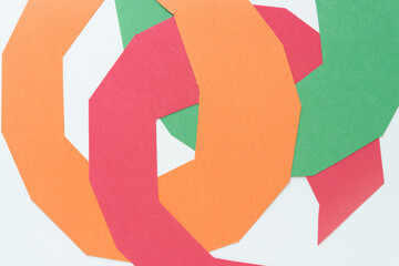 Canvas Print - faceted round construction paper shapes in orange, red, and green, intertwined on blank paper