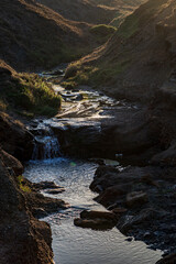 Wall Mural - Morning light shining on a stream of water, at the Isle of Wight coast