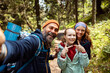 © Davor - Happy family taking selfie while hiking in the woods