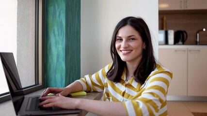 Portrait of a happy woman using laptop at home