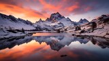 Fototapeta Natura - Panoramic view of snowy mountain peaks reflected in water at sunset