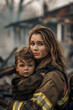 © S photographer - Caucasian female firefighter carries boy out of burnt house ruins.
