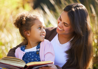 Wall Mural - Mother, child and reading book in park, learning and bonding to connect in childhood at garden. Mama, daughter and relax at outdoor picnic for peace or literature, education and fiction for story