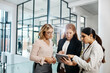 © peopleimages.com - Tablet, businesswomen or talking in meeting at modern office for teamwork, results or collaboration. Entrepreneur, news or group of people speaking in discussion for feedback, planning or project