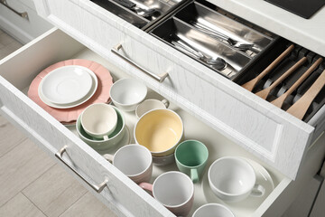 Wall Mural - Ceramic dishware, utensils and cutlery in drawers indoors