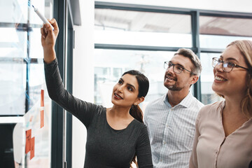 Poster - Woman, teamwork and office with writing on glass board with notes, discussion and planning with brainstorming. Coach, training and group by wall, synergy and collaboration with strategy in workplace