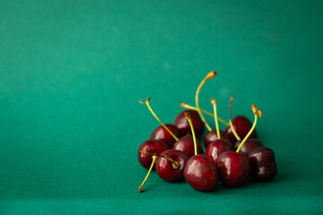 Wall Mural - delicious and healthy cherries. Ripe fruit full of vitamins on a beautiful dark green background