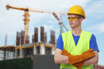 Wall Mural - Young man wearing safety equipment at construction site. Space for text