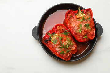 Wall Mural - Tasty stuffed peppers in dish on white table, top view