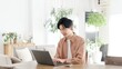 © mapo - 自宅でノートパソコンを使う男性