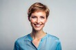 © Adisorn - Happy female model with short haircut and blue blouse stands confidently against a transparent background, radiating warmth and friendliness with her bright smile.