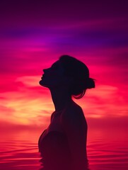 Canvas Print - silhouette of a woman in the water at sunset