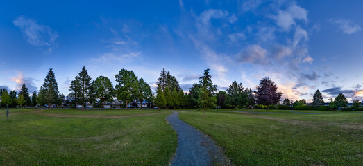 Wall Mural - Pathway in a city park. Colorful Sunset Sky. Panorama. Chilliwack, BC, Canada