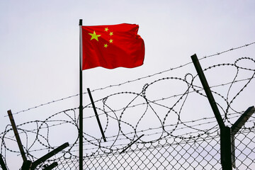 The concept of sanctions pressure on the China government. Chinese flag in barbed wire, sanctions and aggression of China . Chinese prison