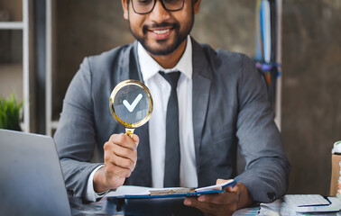 Businessman holding a magnifying glass, showing Audit Document concept,quality assessment. Generative AI.