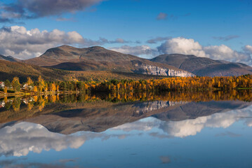 Wall Mural - beautiful mountainous landscape reflected on the water with clouds in the sky -