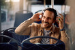 © Drazen - Happy man listening music over headphones in  bus.