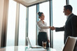 © ReeseArcurs/peopleimages.com - Handshake, team and business people in office with deal, merger or b2b corporate partnership. Meeting, welcome and finance banker shaking hands with investment client for agreement in workplace.