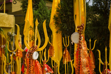 golden colored trident or trishul made of metal kept in hindu temple in India