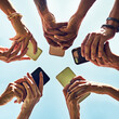 © peopleimages.com - Low angle, smartphone and hands with people, huddle and communication or connectivity. Friends, social media and information sharing with diverse, group and standing in circle outdoors in nature park