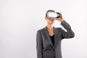 Wall Mural - Skilled businesswoman looking at visual reality world by using VR glass while standing at background. Smart manager holding VR goggle to connect metaverse by using technology innovation. Contraption.