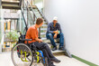 © unai - Man in wheelchair talking with a coworker during work break