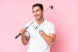 © luismolinero - Young golfer player man isolated on pink background looking up while smiling