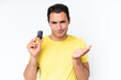 © luismolinero - Young caucasian man holding car keys isolated on white background making doubts gesture while lifting the shoulders