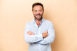 © luismolinero - Middle age caucasian man isolated on beige background keeping the arms crossed in frontal position