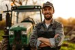 © Athena  - happy Young man farmer with uniform standing in front of his green agricultural tractor