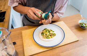 Chef at the kitchen preparing bean porridge with cauliflower and vegetables