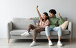 © Prostock-studio - Excited young Asian couple sitting on couch with tablet pc, celebrating online win, great deal or business success at home, free space. Millennial spouses enjoying big sale in web store