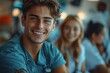 © DKPhoto - A young male medical professional in scrubs, beaming with a friendly smile in a medical setting, representing the dedication, care, and human touch in healthcare.