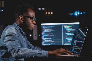 A real picture of a developer coding on his laptop. In the live work environment.
