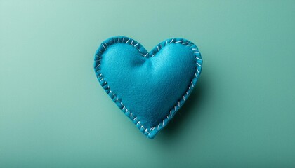 Wall Mural - one teal blue felt stitched toy heart on colored background